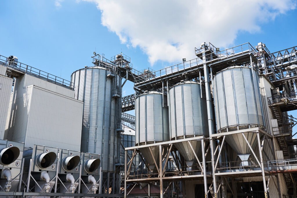 agricultural silos. building exterior. storage and drying of grains, wheat, corn, soy, sunflower against the blue sky with white clouds